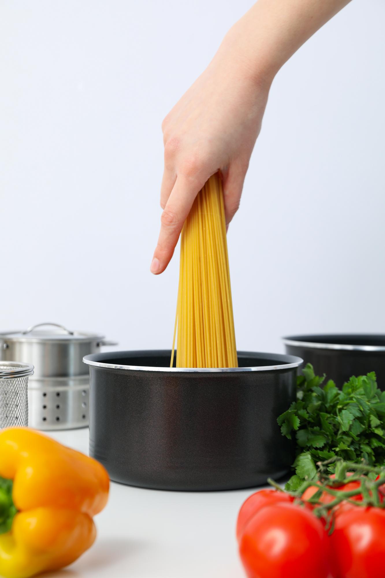 Hands cooking pasta in a studio